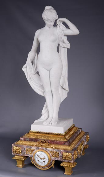 Peach blossom marble and gilt bronze clock surmounted by a statuary white marble   sculpture representing Phryne in front of his judges signed 