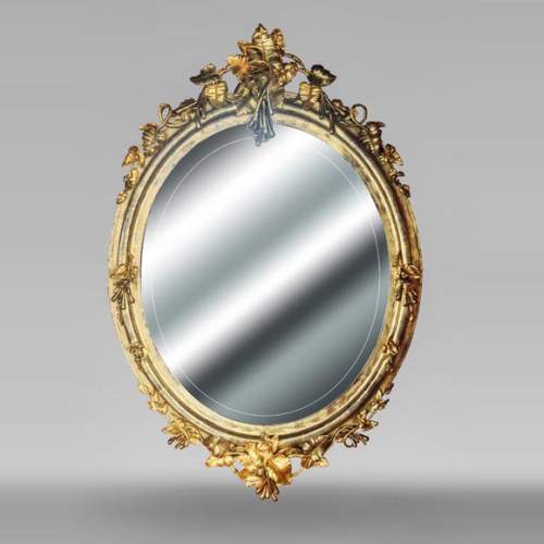Oval gilt mirror in the Napoleon III style, featuring rich foliate ornamentation