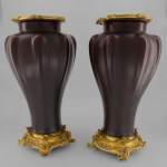 Eugène BAUDIN (att. to), Pair of sandstone vases set in a gilded bronze frame