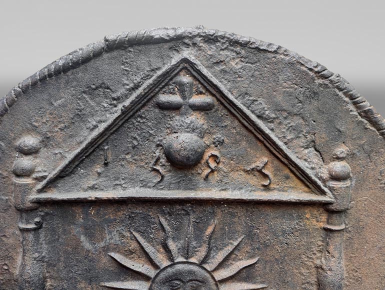 Cast iron fireback dated 1693, decorated with a radiant sun and architectural symbols-1