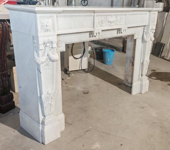 A Louis XVI style fireplace, richly decorated with garlands and vases, in Carrara marble-4