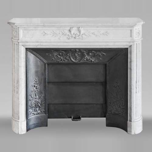 Louis XVI style fireplace with rounded corners and decorated with a laurel wreath, in Carrara marble